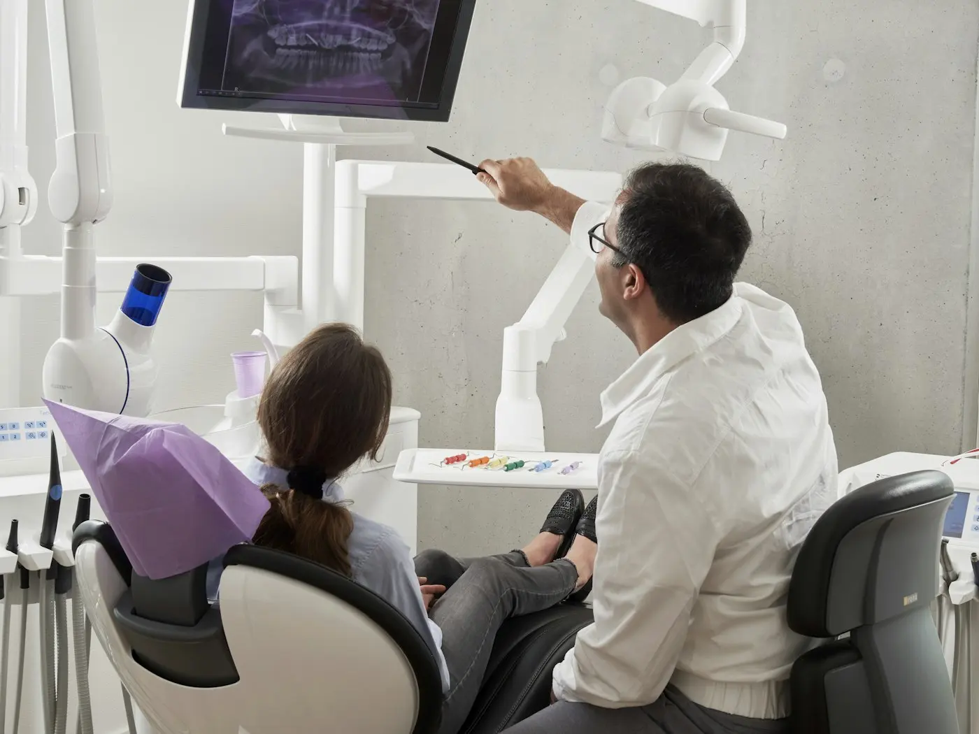 Dentista mostrando una radiografía dental a su paciente en la clínica